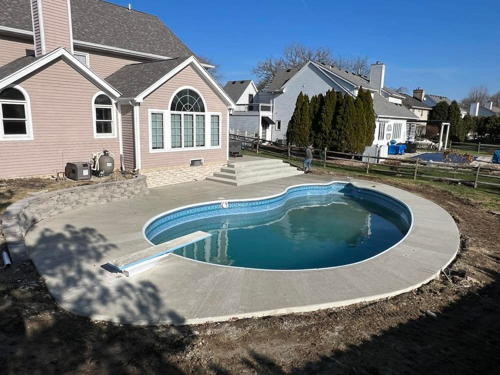 Modern backyard with newly installed swimming pool and landscaped yard in residential setting.
